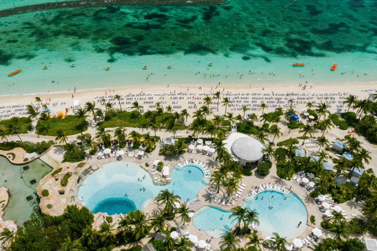 Piscinas de un resort frente a aguas turquesas del Caribe